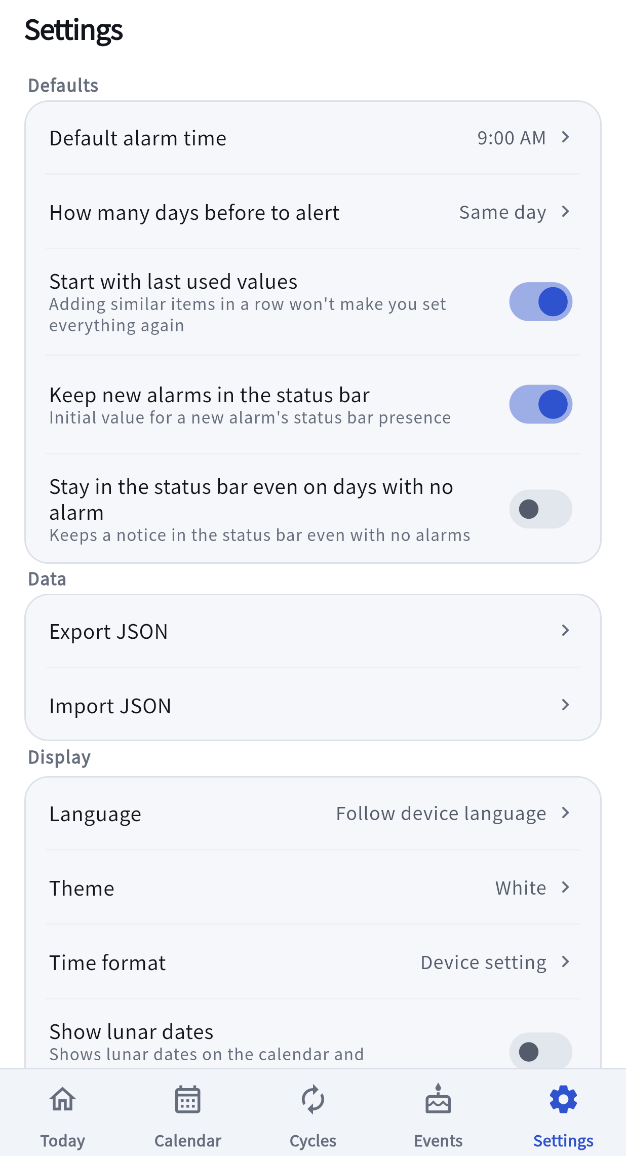The Settings screen: the Defaults section with default alarm time and lead days, the Data section with Export and Import JSON, and the Display section starting with language, theme and time format.